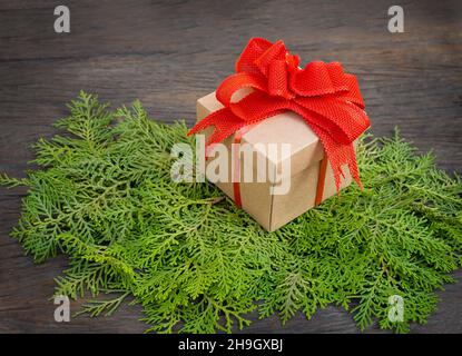 gift box on thuja branches on wooden background Stock Photo