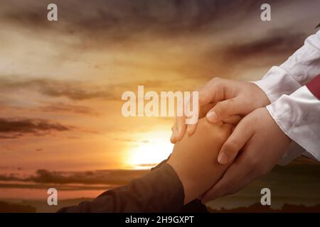 Jesus Christ gave his help to his follower with a sunset background Stock Photo