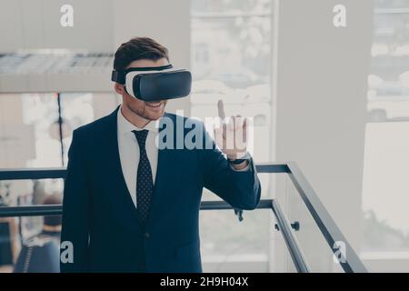 Amazed male office worker in suit being excited while trying out VR glasses Stock Photo