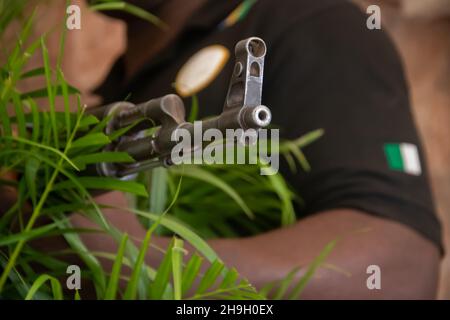 Member of Nigeria special forces holding Kalashnikov aka AK47, resting after military operation in Borno State, Nigeria Stock Photo