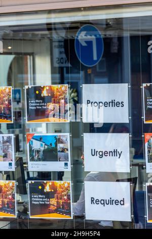 properties urgently wanted sign in the window of a high street estate agent, estate agent window, property market, increasing house prices, greedy Stock Photo