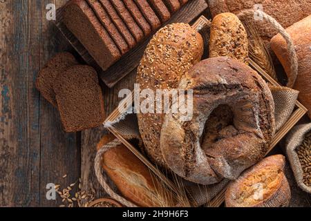 Assortment of different types of bread on a wooden background. Bakery products. Stock Photo