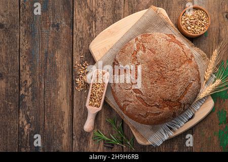 A loaf of rye bread on a wooden background. Top view, copy space. Stock Photo