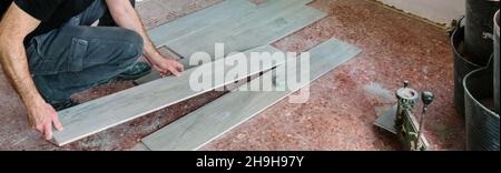 Bricklayer placing tiles to install a floor Stock Photo