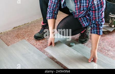 Female bricklayer placing tiles to install a floor Stock Photo