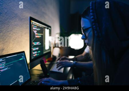 Mobile developers team writes program code on a computer, programmers work in home office. Stock Photo