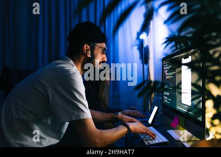 Mobile developers team writes program code on a computer, programmers work in home office. Stock Photo
