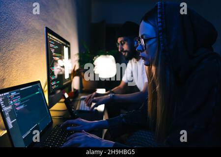Mobile developers team writes program code on a computer, programmers work in home office. Stock Photo