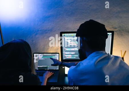 Mobile developers team writes program code on a computer, programmers work in home office. Stock Photo