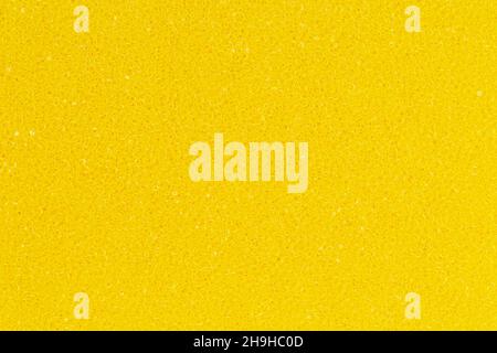 Bright yellow color foam sponge porous texture background. Extreme close-up view of detail abstract synthetic material. Horizontal composition Stock Photo