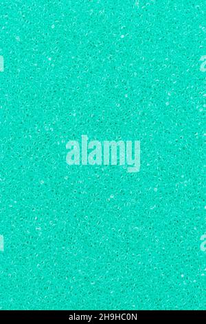 Turquoise color foam sponge porous abstract background. Extreme close-up view of detail synthetic textured material. Vertical composition for design, Stock Photo