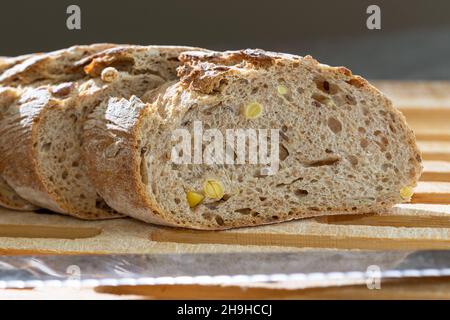 Freshly prepared grain bread slices on a kitchen towel. Various nuts in self made home bread. Closeup Stock Photo