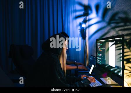 Mobile developers team writes program code on a computer, programmers work in home office. Stock Photo