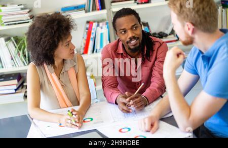 Team of happy successful architects working on construction plans in office. Stock Photo