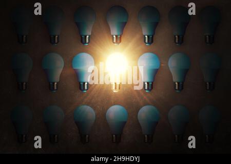 Many light bulbs and one work light bulb lies on a concrete texture, top view. Creative idea and think differently, concept Stock Photo