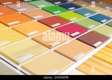 a palette of bright multi-colored wooden blocks painted with terraced oil, a palette for wood coating in a hardware store Stock Photo
