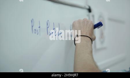 Smart man writing on whiteboard. Clip. Close up of man writes the writing on Board. Stock Photo