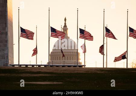 Washington, DC, USA. 07th Dec, 2021. US national flags fly at half-staff at the base of the Washington Monument by presidential proclamation, to honor the late former US Senate Majority Leader Bob Dole, in Washington, DC, USA, 07 December 2021. Dole died on 05 December at the age of 98. Credit: Michael Reynolds/Pool via CNP/dpa/Alamy Live News