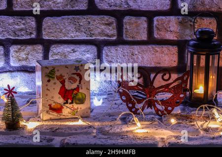 Happy New Year 2022 and Christmas concept with wooden numbers, a gift box, and party mask. Stonewall theme in the background. Copy Space Stock Photo