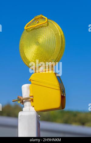 Flashing Yellow Construction Light at Top of Barrier Sky Stock Photo