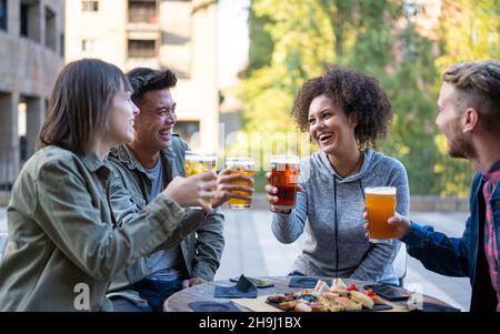 Happy friends having fun, group of millennials friends cheering sport at bar together Stock Photo
