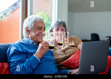 Happy old senior couple with laptop computer having video call, retirement senior couple lifestyle old age using connecting technology, quarantine con Stock Photo