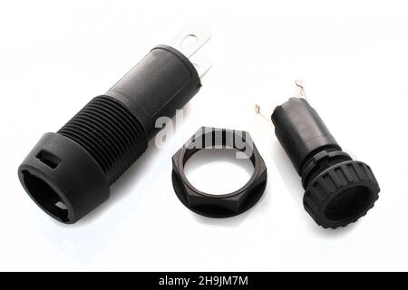 Black plastic electronic fuse holder for panel mount on white background Stock Photo