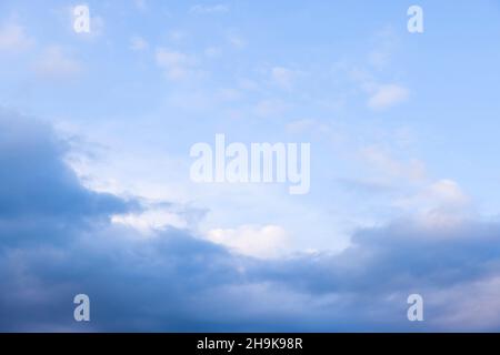 Dark rain clouds against a blue sky background, ideal for a moody sky background Stock Photo