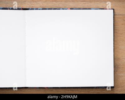 Artists sketchbook, sketch book, notebook. Empty plain white paper page open on a wooden desk or table, flat lay Stock Photo