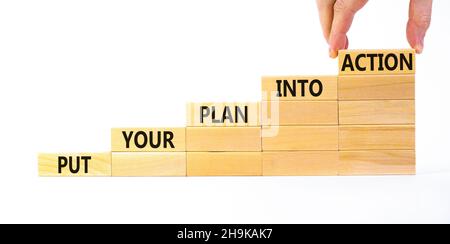 Put your plan into action symbol. Wooden blocks with words Put your plan into action. Beautiful white background, copy space. Businessman hand. Busine Stock Photo