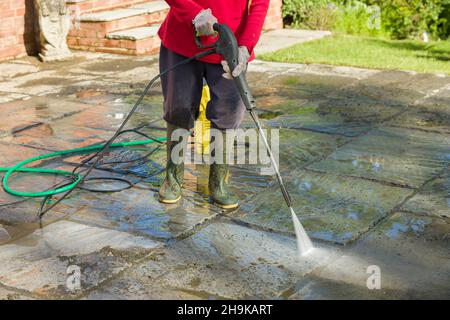 Jet washing, pressure washing or cleaning a garden patio with a jet wash, UK Stock Photo