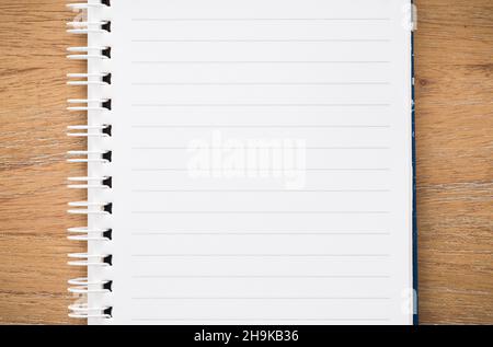 Closeup of empty lined notebook open on a wooden desk, from above. Flat lay template, border or background with copy space Stock Photo