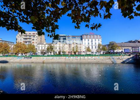 Bucharest, Romania, 22 November 2020 - Dambovita river, old buildings and yellow, orange and brown leaves in large trees in the center of Bucharest, R Stock Photo