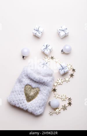 White fluffy sack with small gift boxes on beige background, flat lay vertical Stock Photo