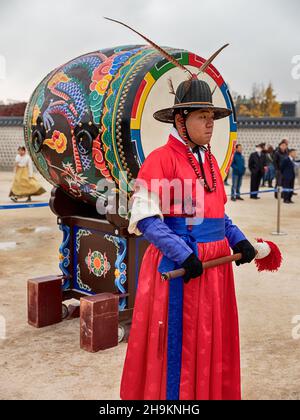 SEOUL, KOREA - NOVEMBER 17, 2019: At the changing of the guard ceremony at the Gyeongbokgung royal palace in Seoul, a soldier will strike the drum. Stock Photo