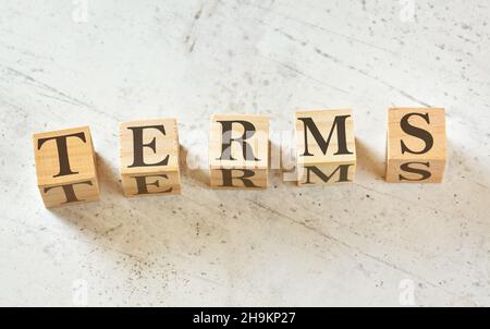 Five wooden cubes with word TERMS on white stone like board, view from above Stock Photo