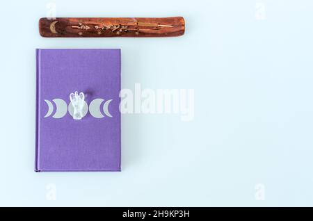 Flat lay of moon journal with angel quartz crystal and burning incense on white background with copy space Stock Photo