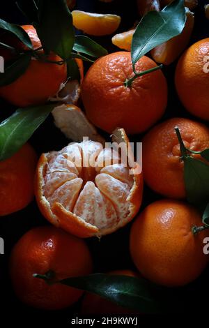 Fresh tangerines with green leaf isolated on dark background. Directly above. Stock Photo