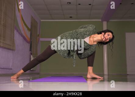 Woman presents yoga poses ./Yoga woman practicing yoga exercises in the gym. Stock Photo