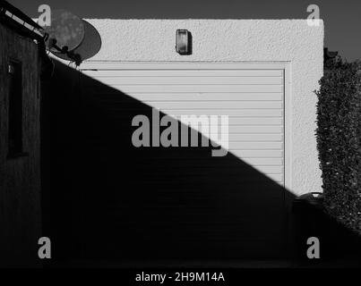 White garage door with half in the shade and half in sunlight. Stock Photo