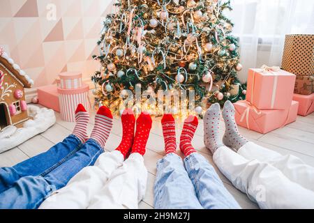 Close up photo of family feet in woolen socks by the christmas tree Stock Photo
