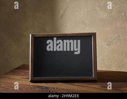 blackboard in a wooden frame on a table in the interior of the room Stock Photo