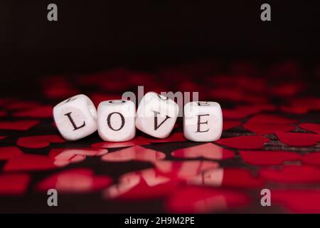 The word LOVE from wooden cubes on dark wood. St. Valentine's Day background Stock Photo