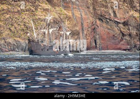 Renovated old wooden pirate ship sailing along coast. Stock Photo