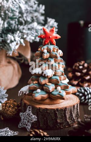 Gingerbread Christmas tree on table with seasonal decor and natural pine cones on dark background, copy space Stock Photo