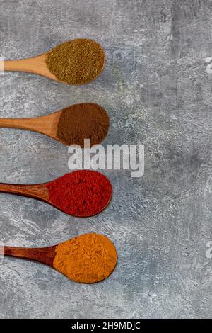 Looking down on colourful ground spices against a grey background Stock Photo