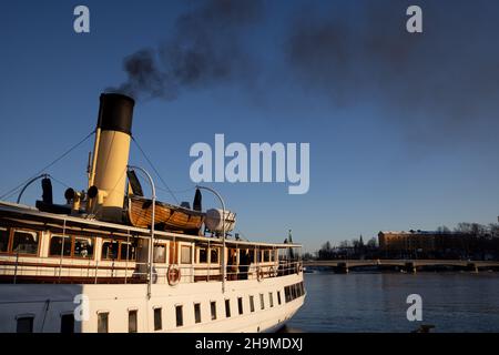 Air pollution in Stockholm. Chimney of boat with black smoke coming out of it. Climate change and carbon emission theme. Stock Photo