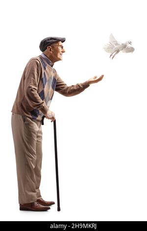 Full length profile shot of an elderly man with a white dove isolated on white background Stock Photo