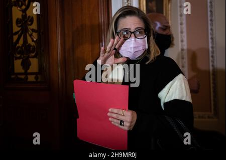 Washington, USA. 07th Dec, 2021. Senator Kyrsten Sinema (D-AZ) waves while entering the Senate Chamber at U.S. Capitol, in Washington, DC, on Tuesday, December 7, 2021. During a hectic week of negotiations on Capitol Hill, President Biden today will speak with Russian President Vladimir Putin about Russian troop build up on the border with Ukraine and the conflict there. (Graeme Sloan/Sipa USA) Credit: Sipa USA/Alamy Live News Stock Photo