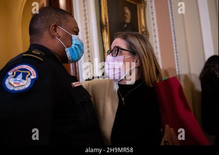 Washington, USA. 07th Dec, 2021. Senator Kyrsten Sinema (D-AZ) embraces Capitol Police Officer Eugene Goodman at the U.S. Capitol, in Washington, DC, on Tuesday, December 7, 2021. During a hectic week of negotiations on Capitol Hill, President Biden today will speak with Russian President Vladimir Putin about Russian troop build up on the border with Ukraine and the conflict there. (Graeme Sloan/Sipa USA) Credit: Sipa USA/Alamy Live News Stock Photo